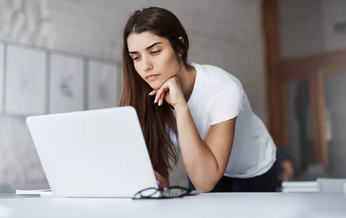 Una chica observa su ordenador después de recibir un correo extraño de InfoJobs que puede ser una estafa / FREEPIK - lookstudio