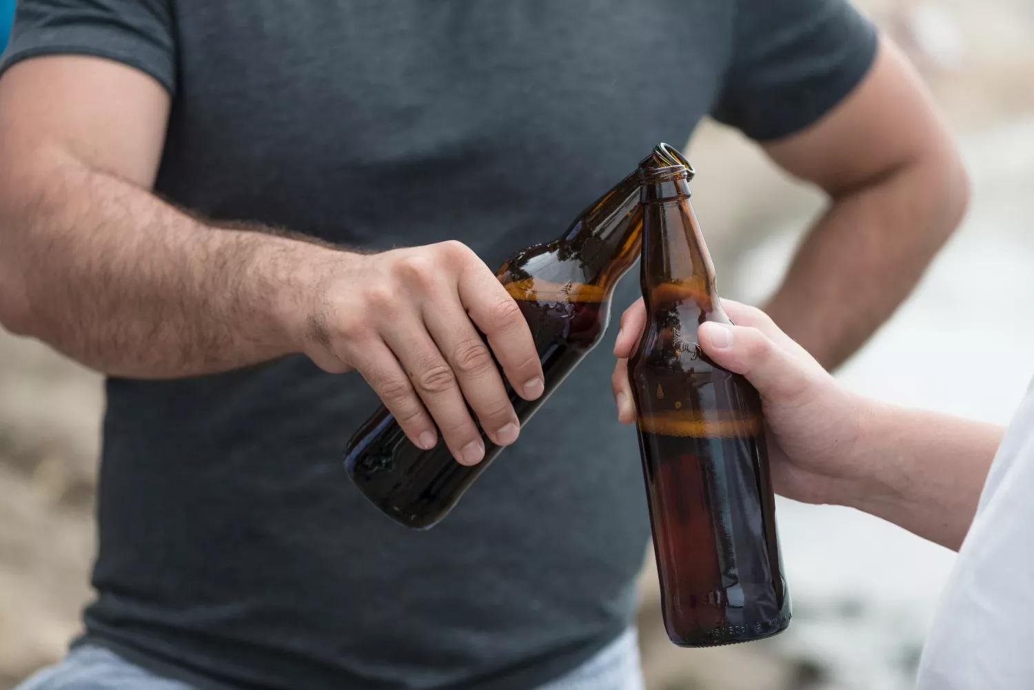 Dos personas brindan con una cerveza similar a la de Estrella Galicia / FREEPIK