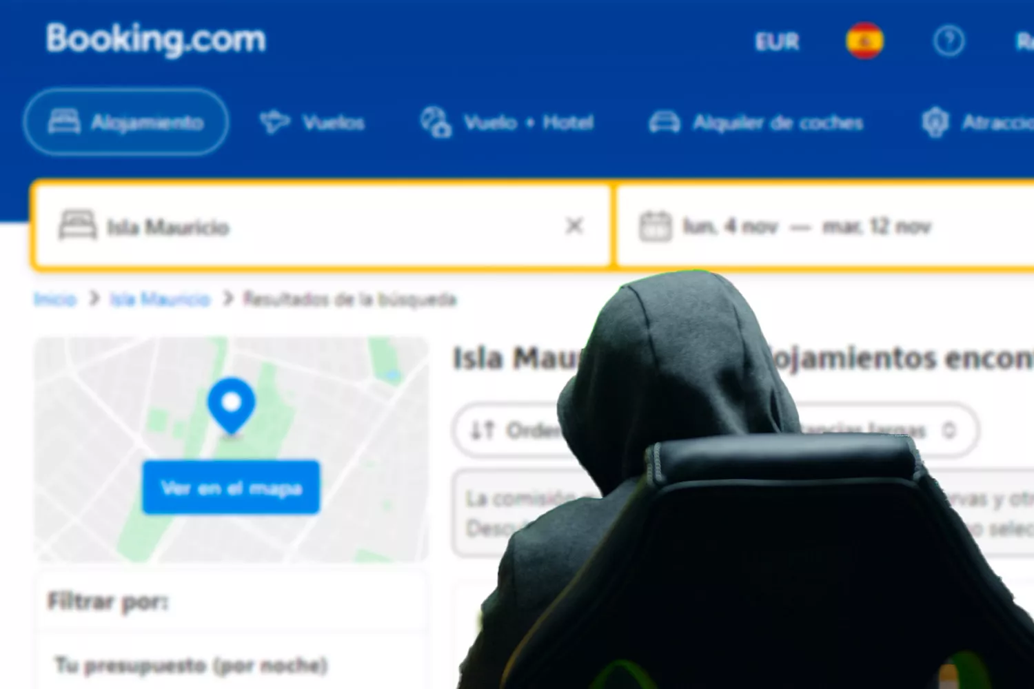 Un ciberdelincuente robando en Booking / Fotomontaje CG