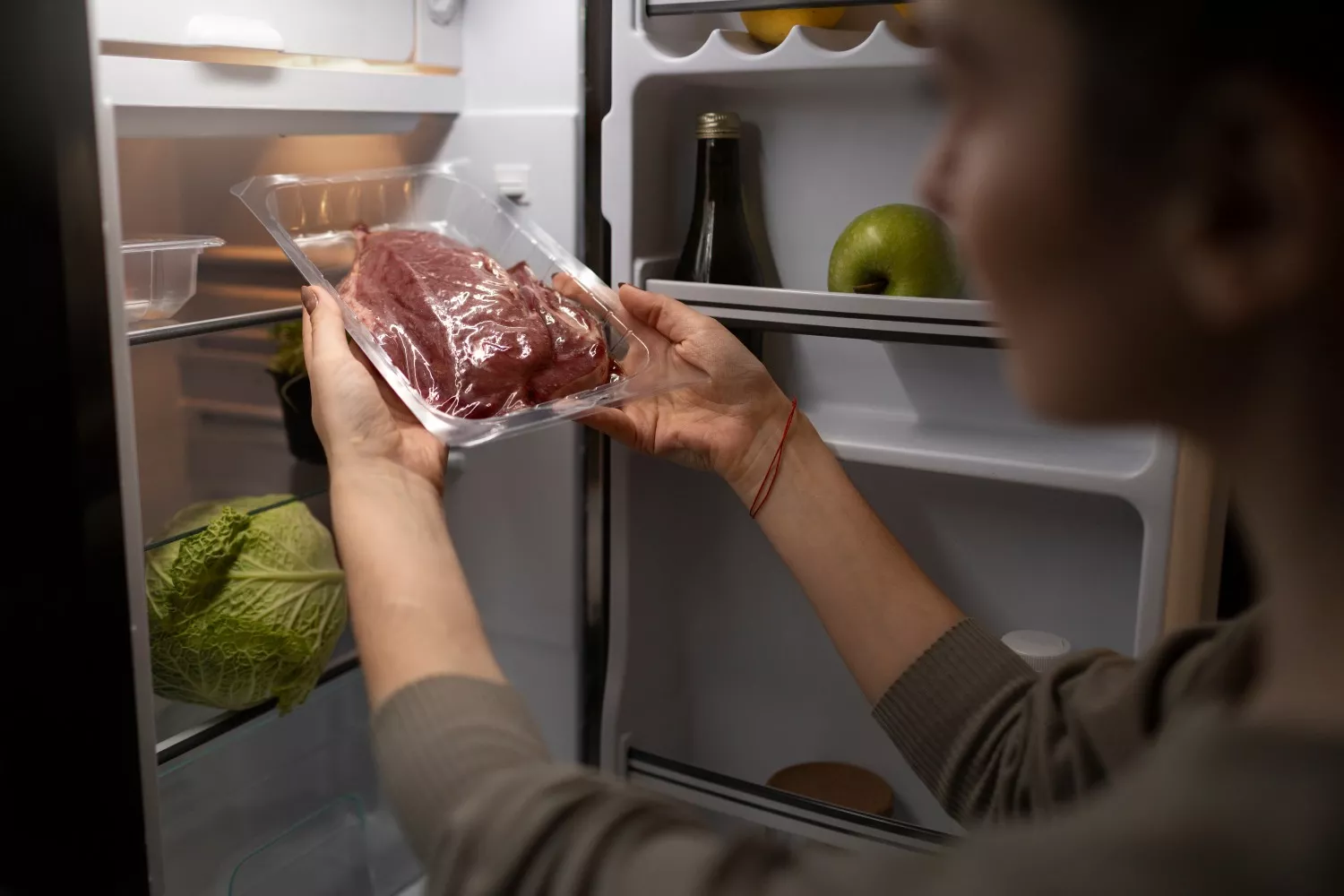 Uma pessoa guarda a carne no frigorífico / FREEPIK