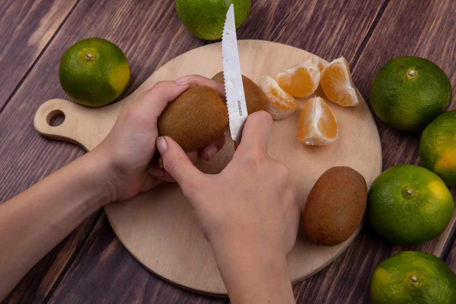 Una persona parte un kiwi con un cuchillo / FREEPIK - stockking