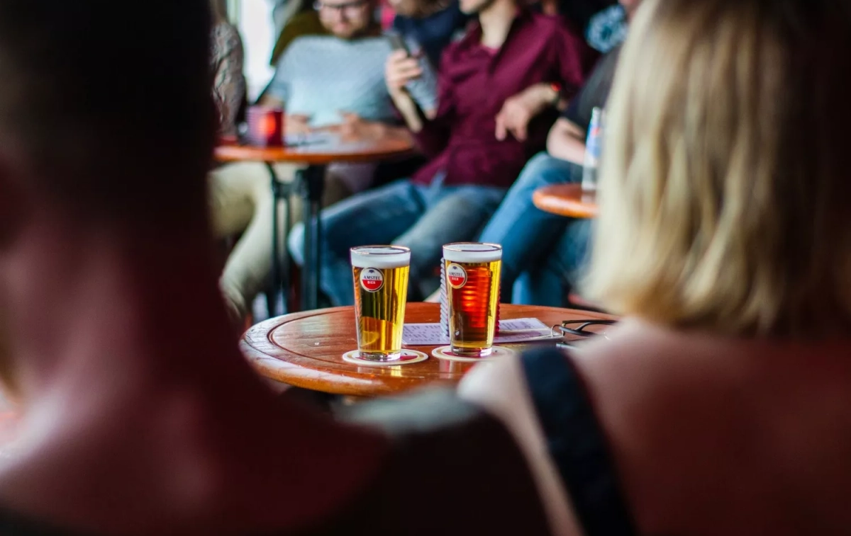 Varias personas en un bar beben cerveza / UNSPLASH