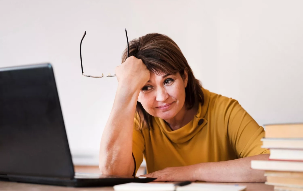 Una mujer, aburrida frente a su ordenador / FREEPIK