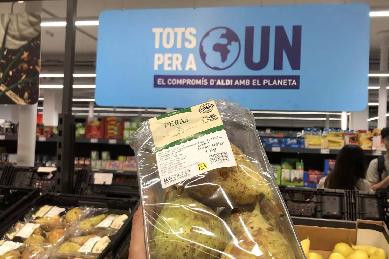 Unas peras platificadas y un letrero sobre el compromiso de Aldi con el planeta / TEO CAMINO