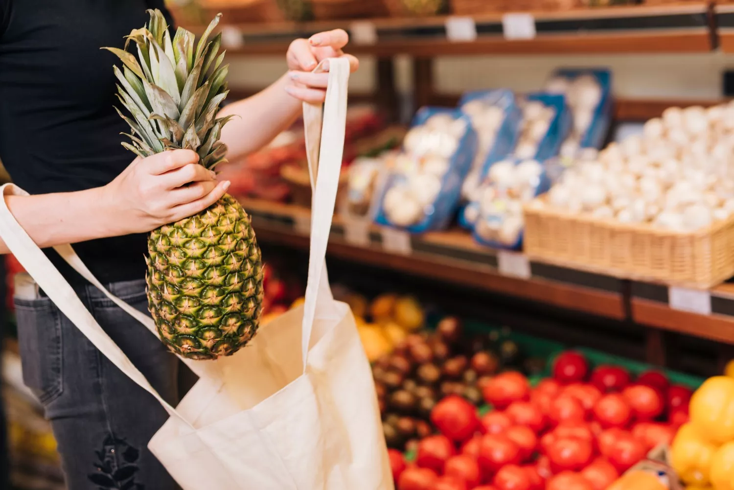 Una persona sostiene una piña en un supercado similar a Mercadona / FREEPIK