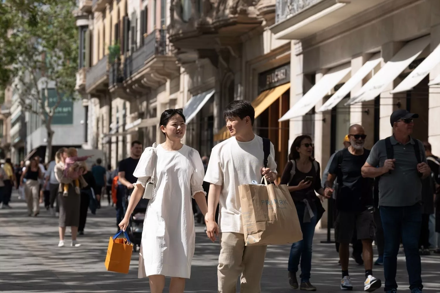 Varias personas de compras por el Paseo de Gracia de Barcelona, donde Hugo Boss abrirá una nueva tienda / EP - DAVID ZORRAKINO