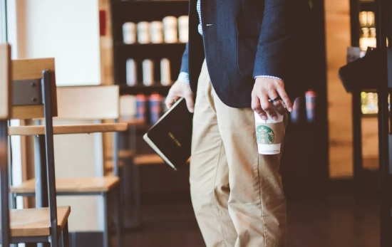 Una persona con un café para llevar / UNSPLASH