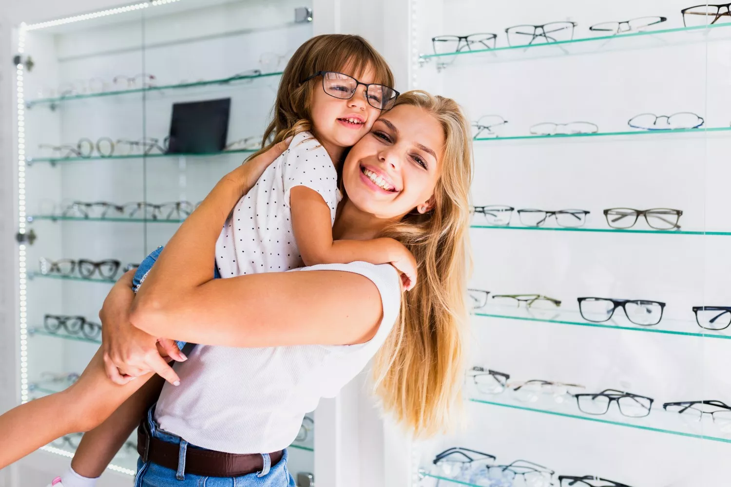 Una mujer junto a su hija con miopía en una óptica / FREEPIK