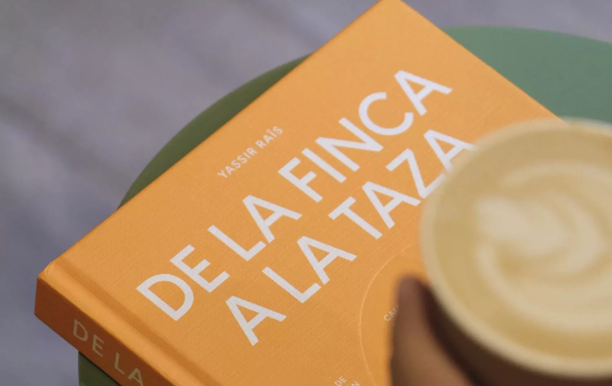 El nuevo libro de Yassir Raïs, 'De la finca a la taza', junto a un café / SYRA COFFEE