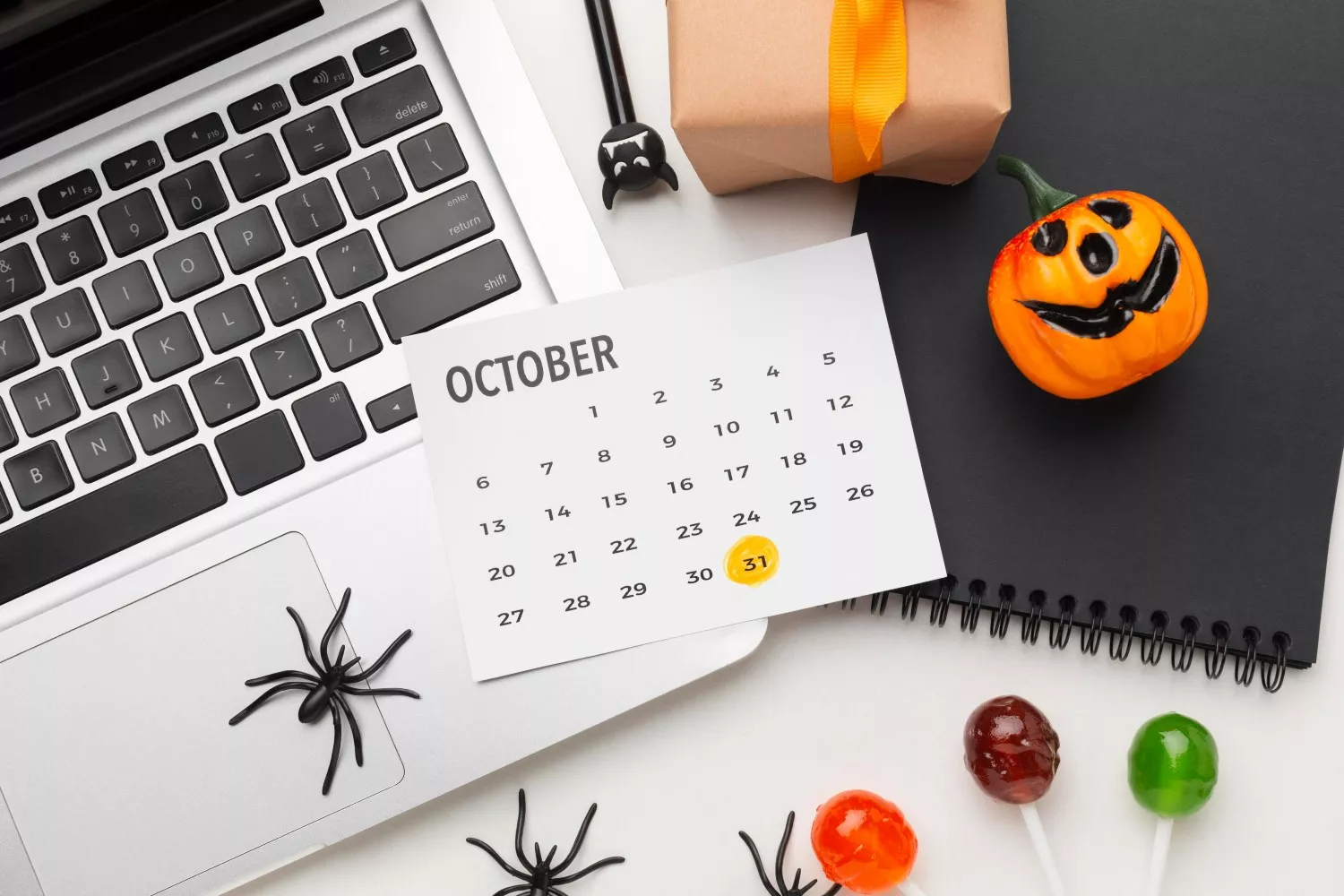 Un ordenador junto a un calendario y artículos de Halloween / FREEPIK