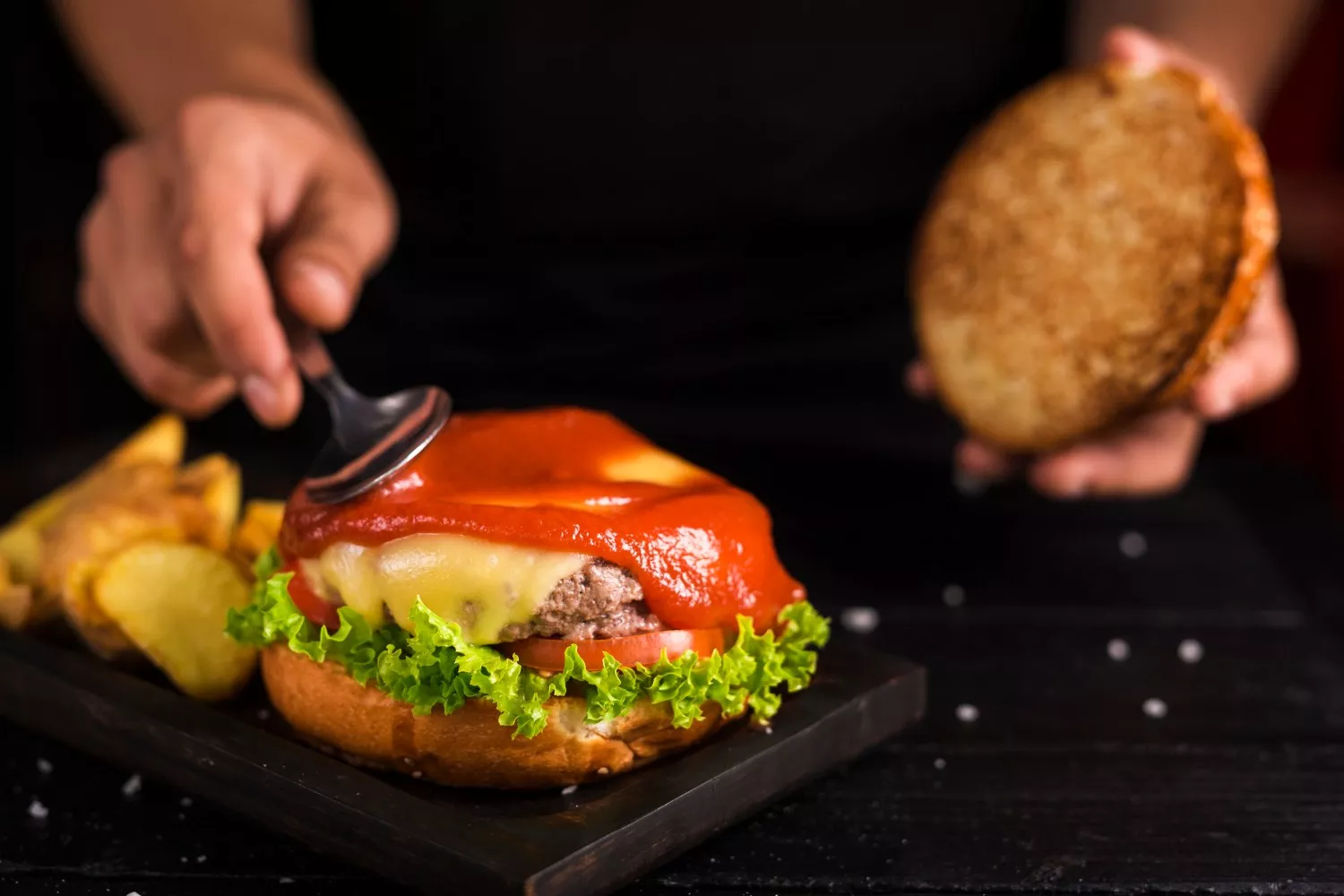 Un cocinero prepara una hamburguesa / FREEPIK