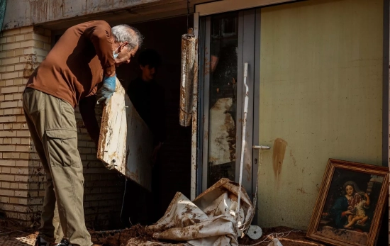 Un hombre tratando de limpiar su vivienda tras ser anegada por la lluvia /EuropaPress