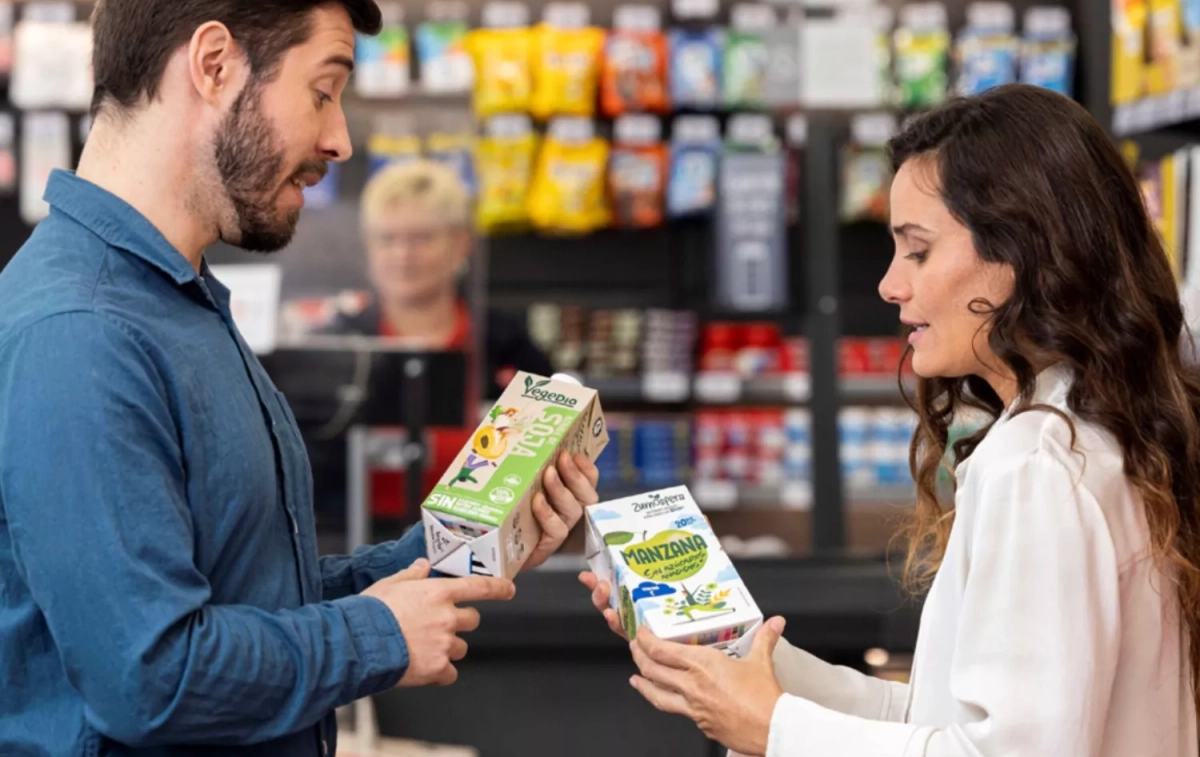 Dos personas comparan dos bebidas en un comercio / DIA