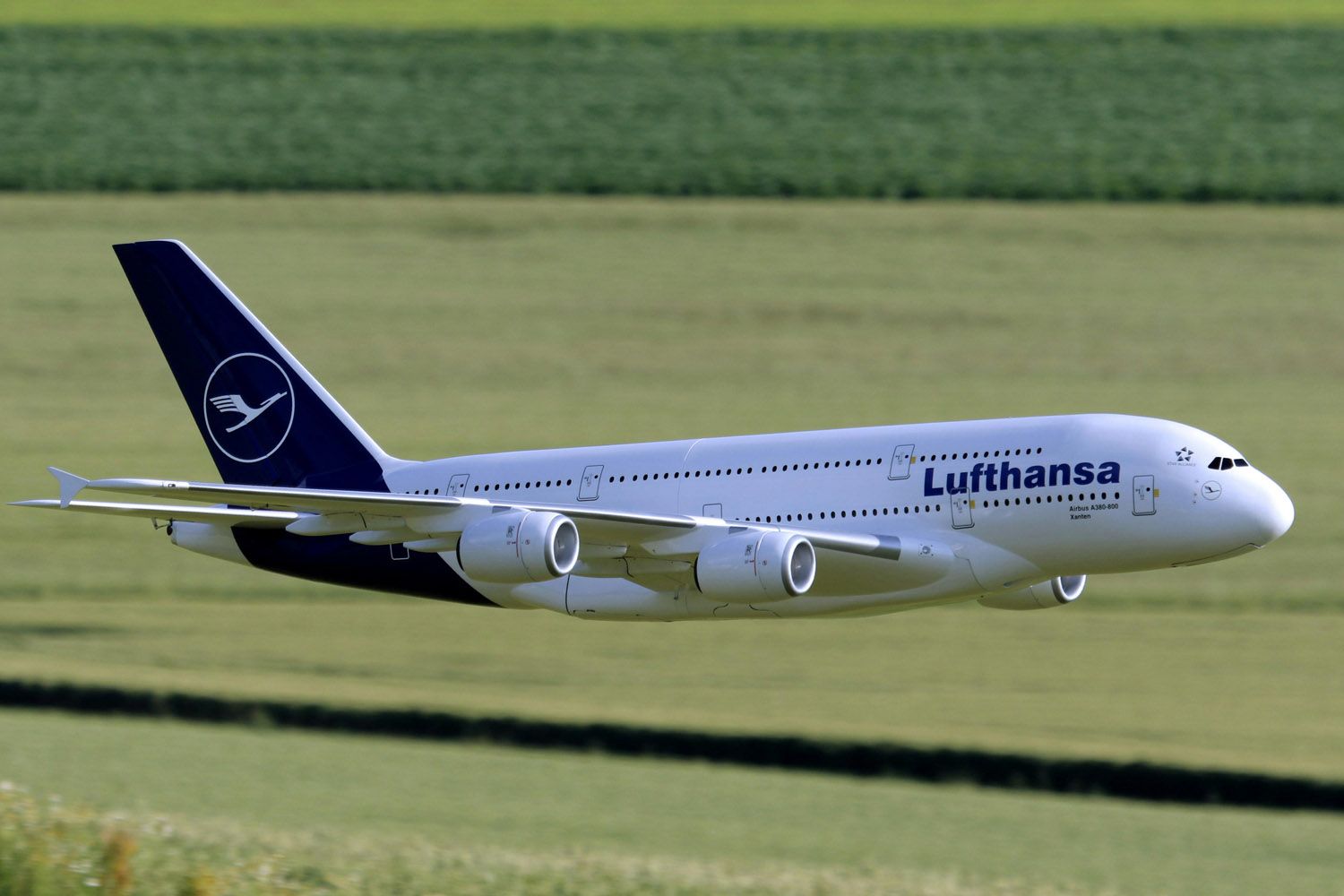 Un avión de Lufthansa sobrevuela unos campos PEXELS