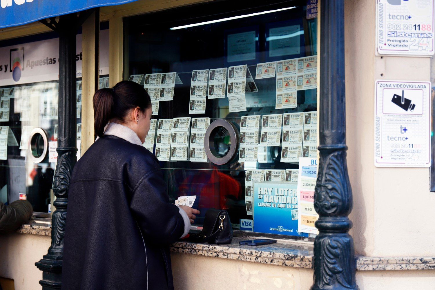 Una chica busca unas terminaciones concretas para el sorteo de Lotería de Navidad / EUROPA PRESS - ÁLEX ZEA