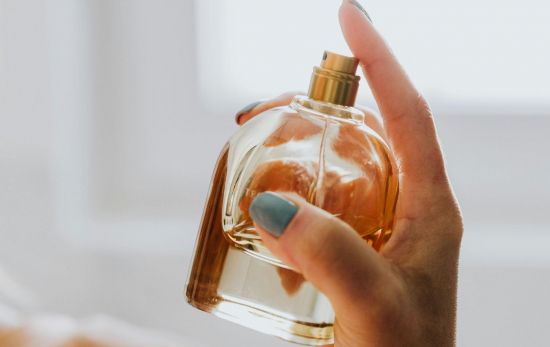 Una mujer se aplica un perfume con notas 'oud' / PEXELS