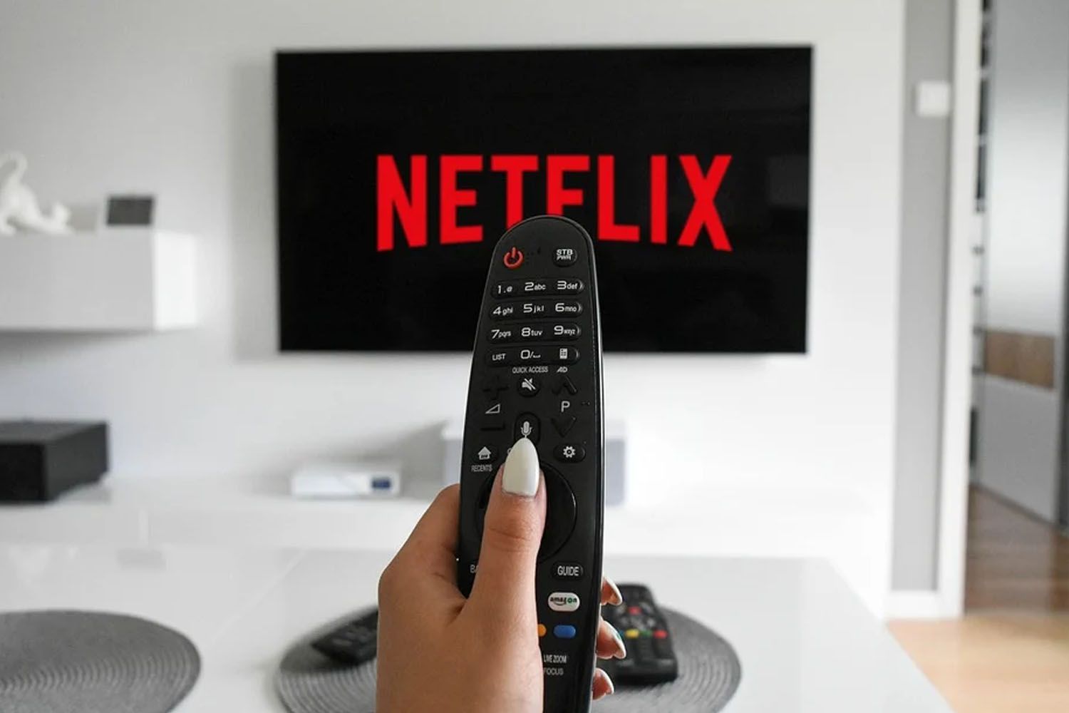 Un hombre con el mando y Netflix en el televisor / PEXELS