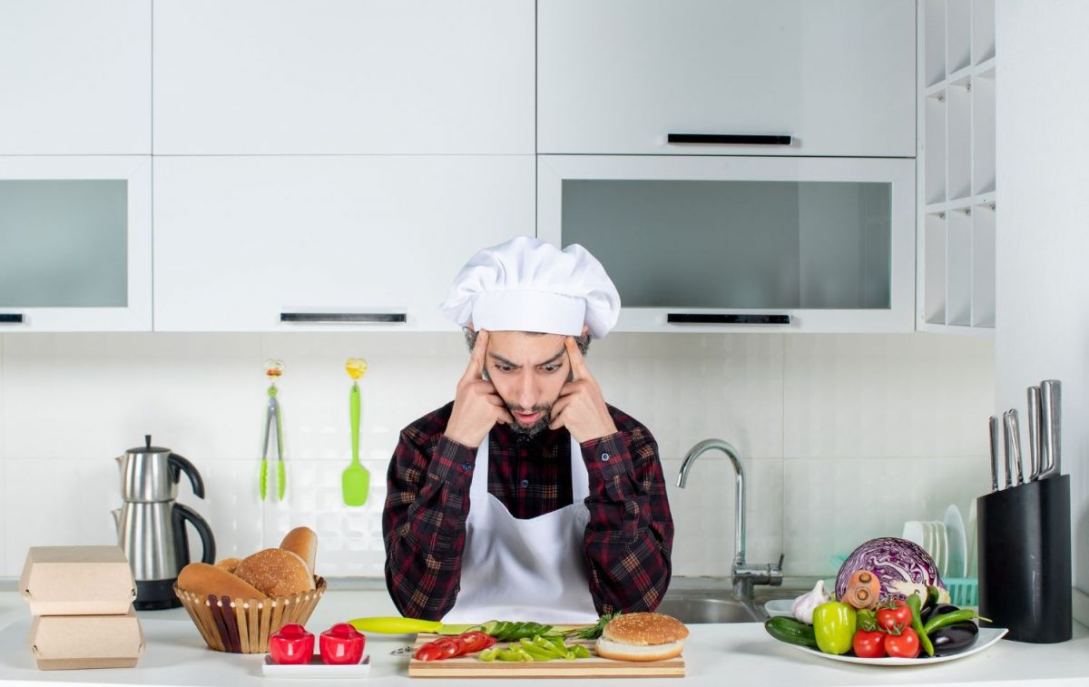 Un cocinero que se apoya sobre la encimera / FREEPIK