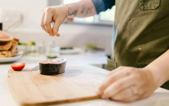 Una persona sazona una pieza de salmón para la cena/ PEXELS Una persona sazona una pieza de salmón para la cena/ PEXELS