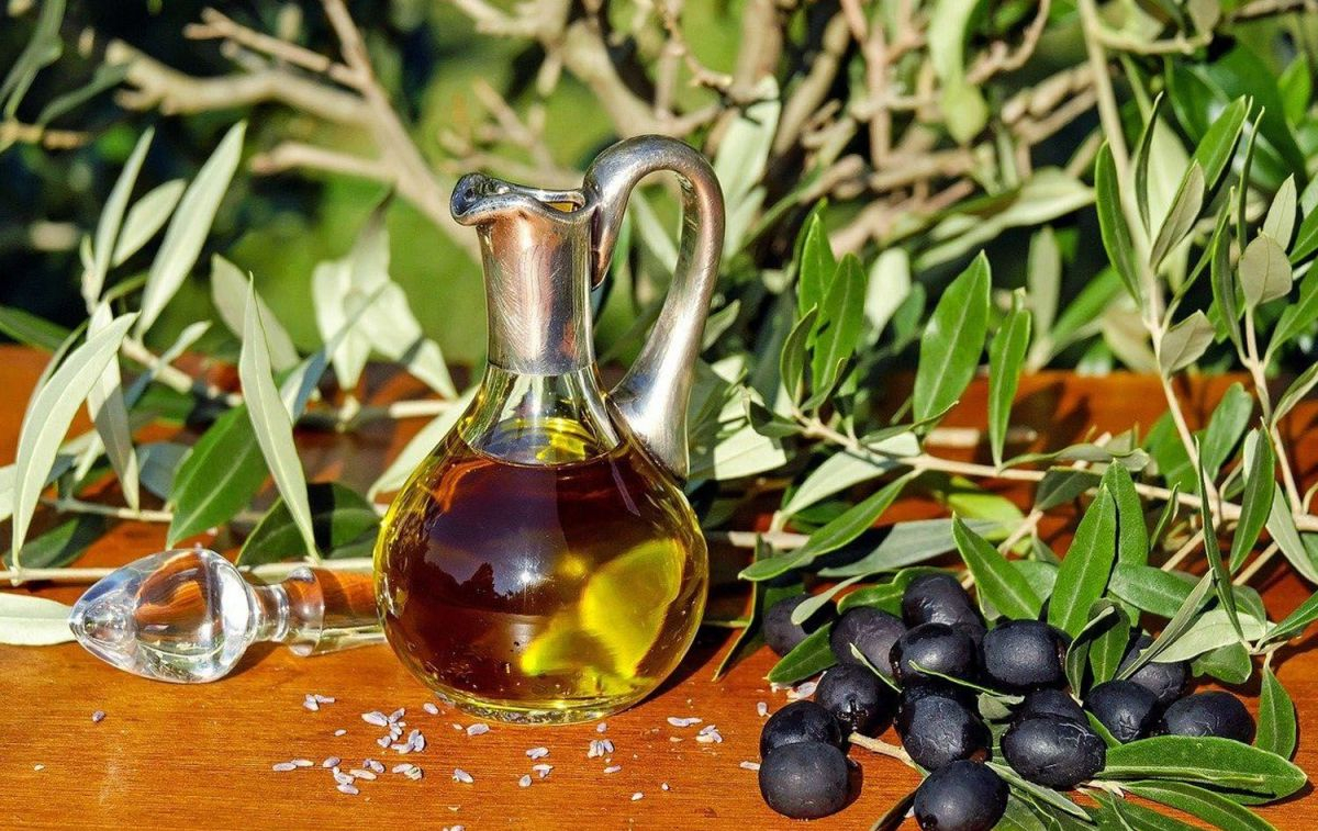 Un frasco de aceite de oliva acompañado de unas aceitunas negras / PIXABAY