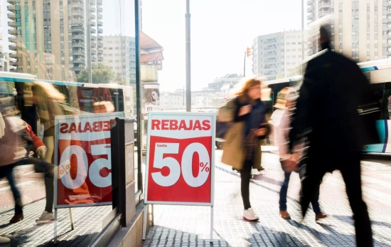 Consumidores españoles junto a un cartel que anuncia rebajas / FREEPIK Consumidores españoles junto a un cartel que anuncia rebajas / FREEPIK