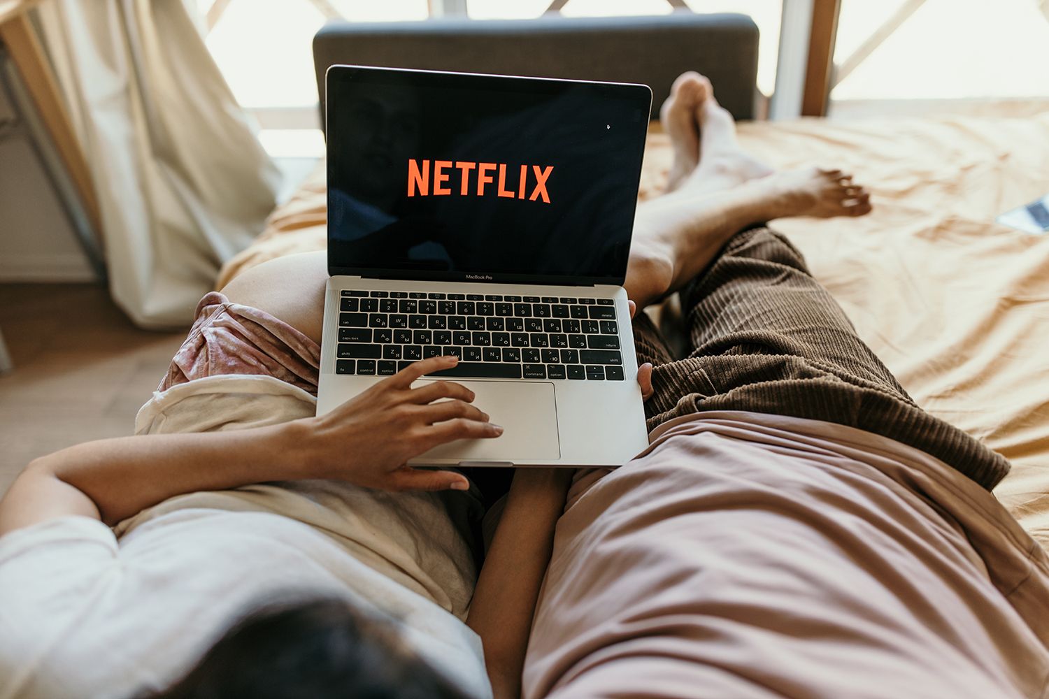 Dos personas ven Netflix en su ordenador portátil / PEXELS