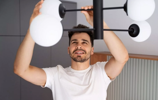 Una persona instala bombillas que emiten luz / FREEPIK Una persona instala bombillas que emiten luz / FREEPIK