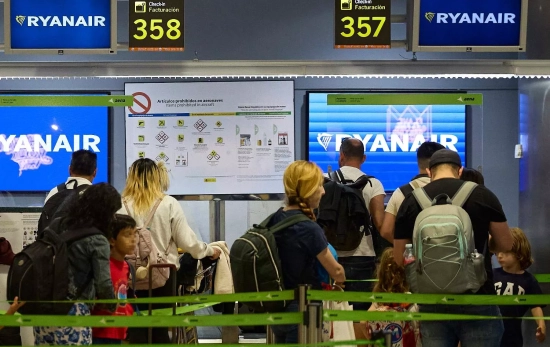Un grupo de personas en un puesto de facturación de Ryanair en el Aeropuerto Adolfo Suárez Madrid Ba Un grupo de personas en un puesto de facturación de Ryanair en el Aeropuerto Adolfo Suárez Madrid Ba