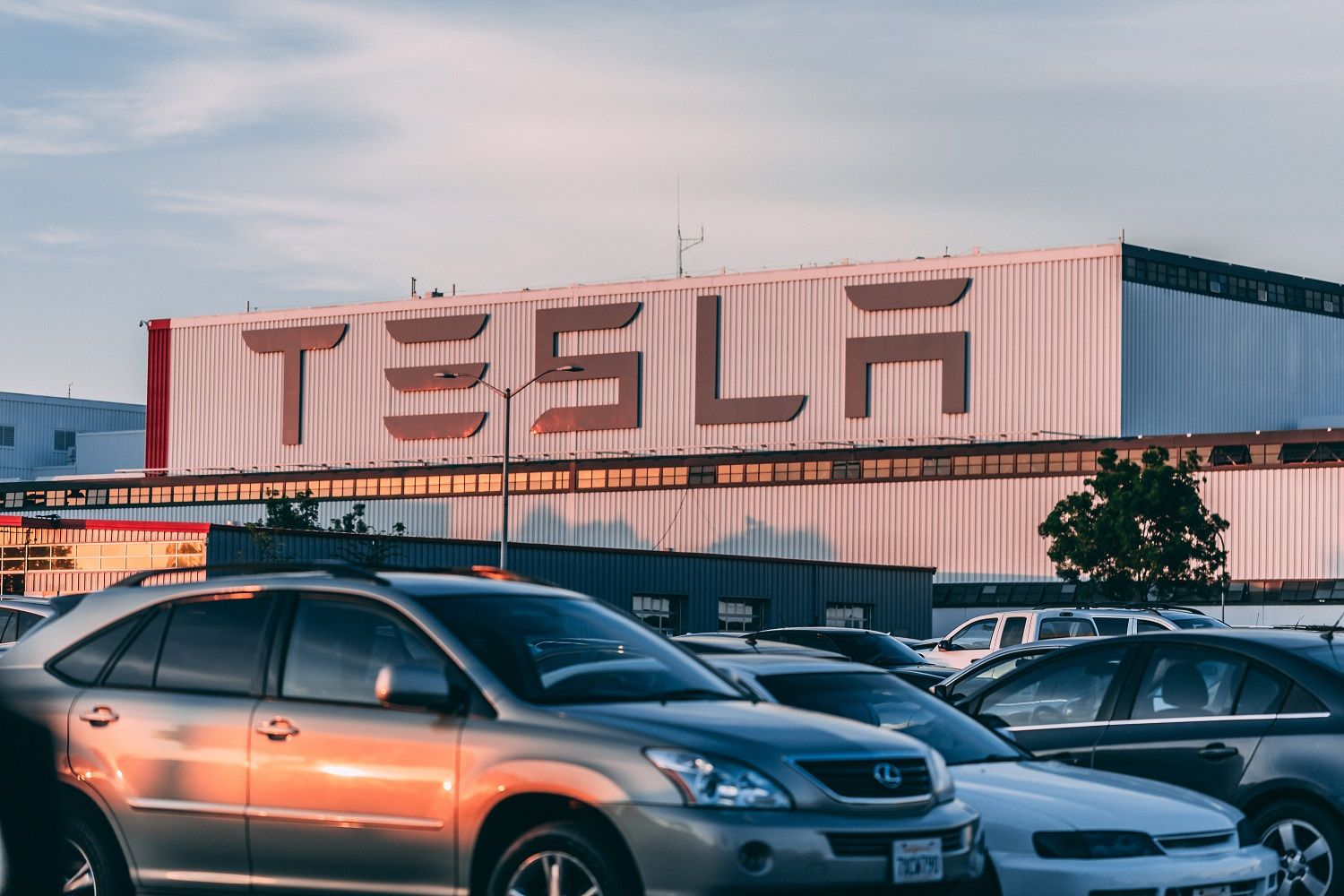 Vehículos aparcados delante de una fábrica de Tesla / PEXELS