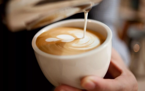 Un barista sostiene una taza de café espumado/ PIXABAY Un barista sostiene una taza de café espumado/ PIXABAY