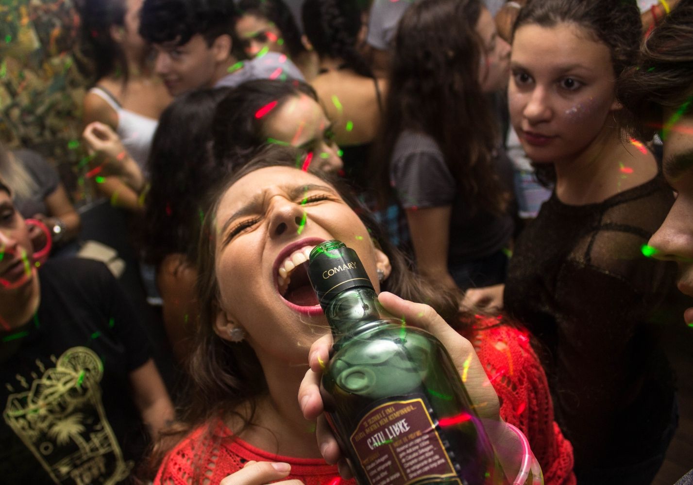 Una mujer joven bebiendo de una botella de alcohol / PEXELS