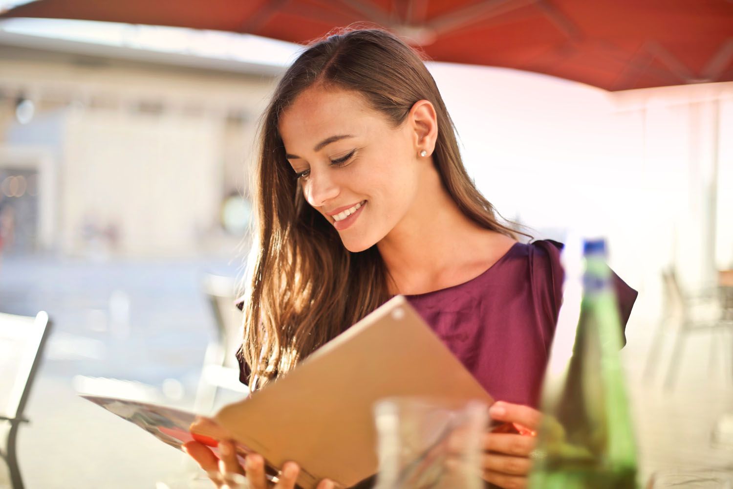 Una mujer hojea el menú de un restaurante / PEXELS