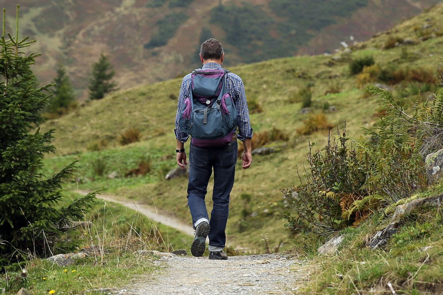 Un hombre camino por el campo en una zona rural cercana a un pequeño pueblo / Pexels