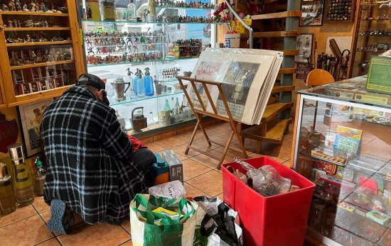 Un vendedor ambulante repasa sus objetos en el suelo / TC Un vendedor ambulante repasa sus objetos en el suelo / TC