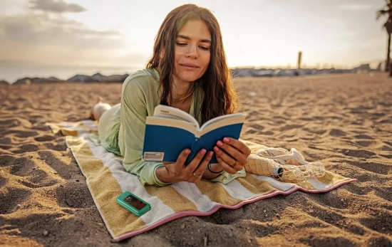 Una chica lee junto a un móvil de SPC Una chica lee junto a un móvil de SPC