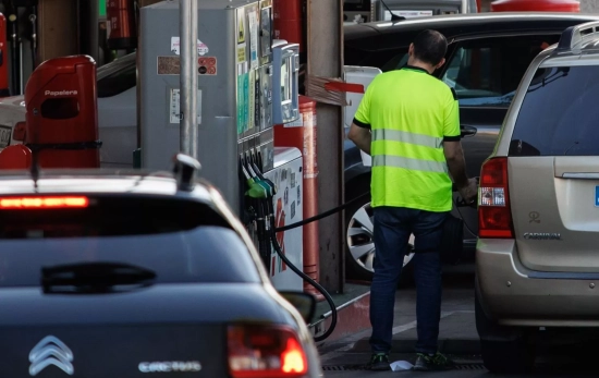 Un hombre echa carburante a su vehículo en una gasolinera, Un hombre echa carburante a su vehículo en una gasolinera,