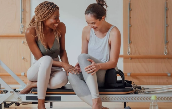 Unas chicas en clase de pilates reformer/ CANVA Unas chicas en clase de pilates reformer/ CANVA