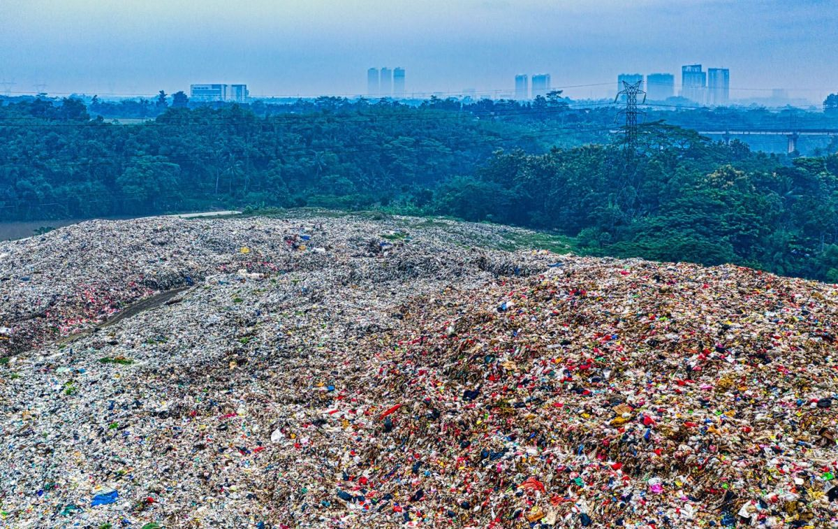 Montañas de plástico para reciclaje y una ciudad al fondo / PEXELS