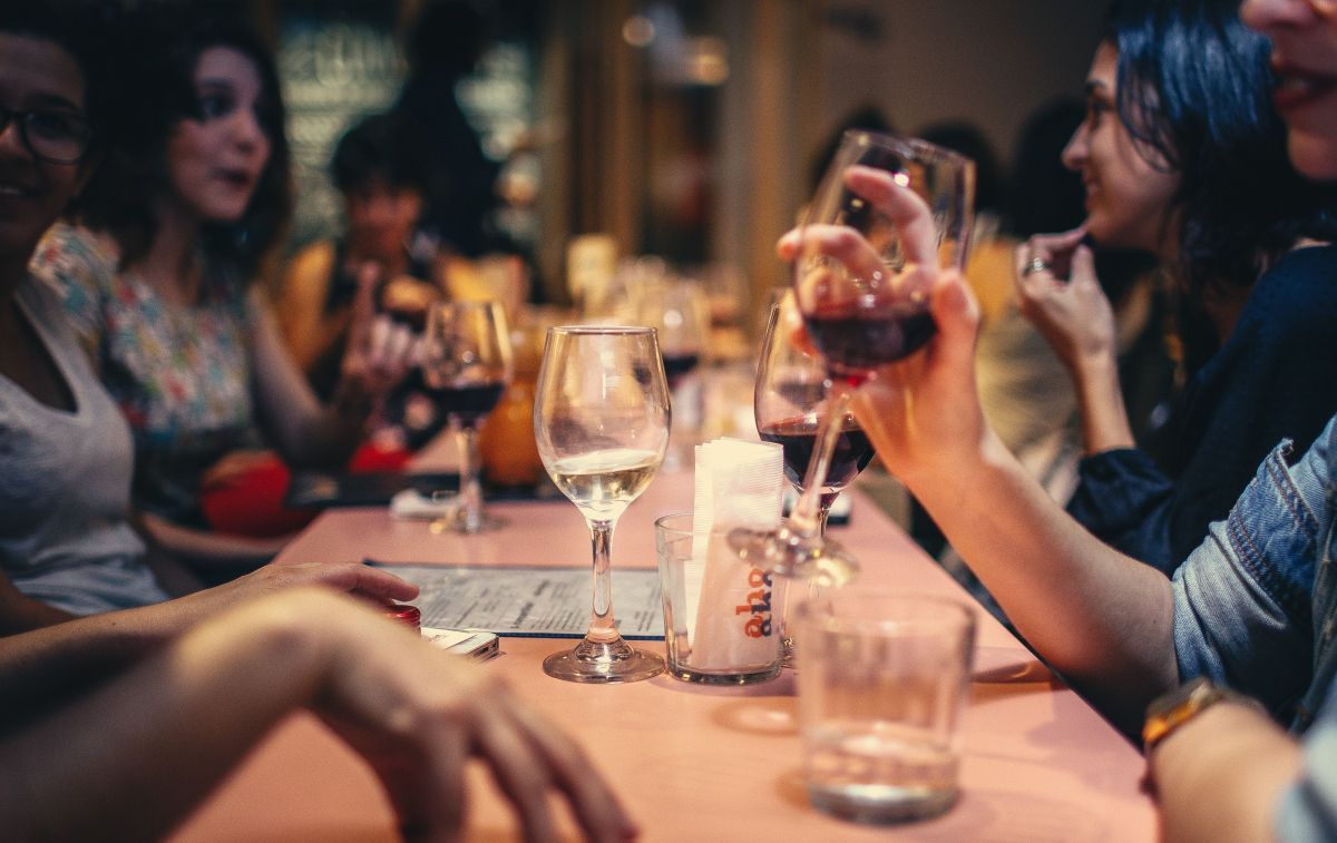 Un consumidor levanta su copa de vino durante una reunión con amigos / PEXELS