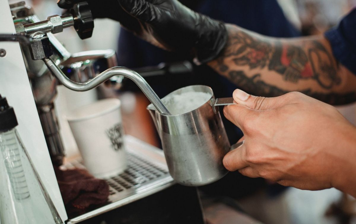 Un camarero rellena una taza de leche y comete un error con el café / PEXELS