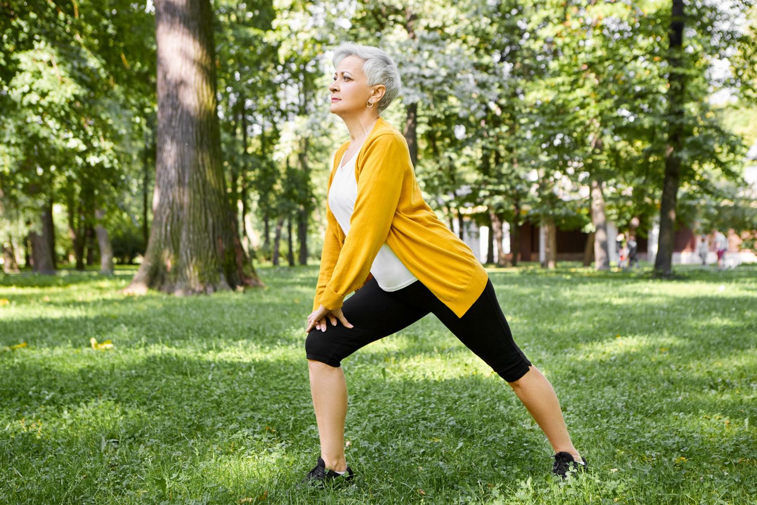 Una mujer estira sus piernas cansadas en un parque