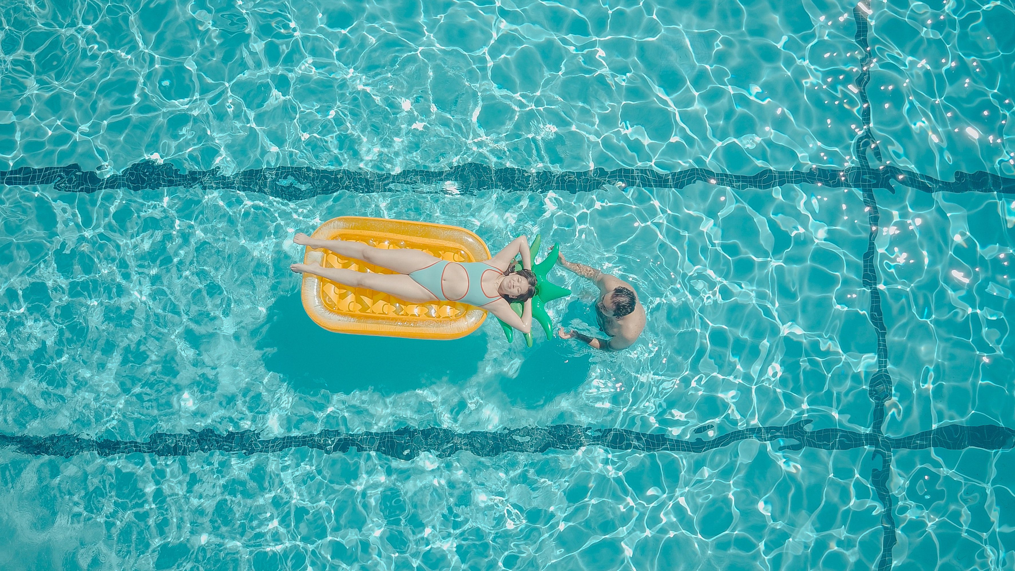 Una pareja se relaja en la piscina de su urbanización / PEXELS